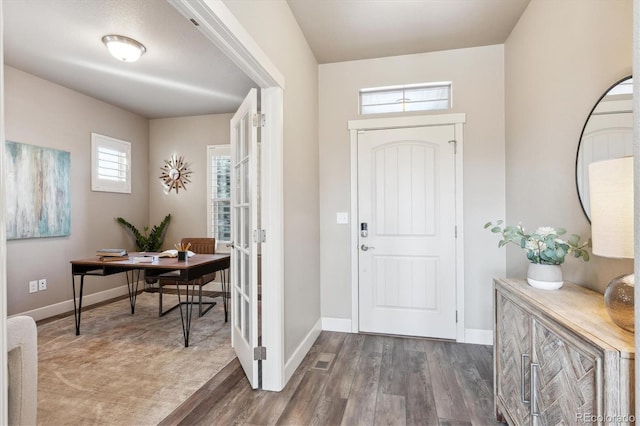 foyer entrance featuring a textured ceiling, dark hardwood / wood-style flooring, a healthy amount of sunlight, and french doors