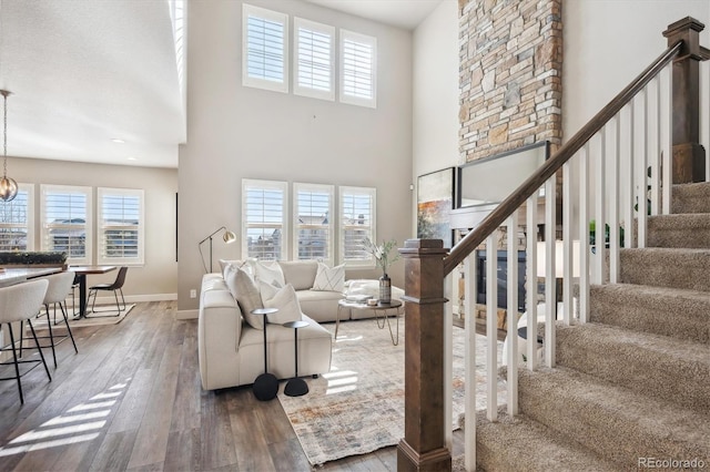 living room featuring plenty of natural light, wood-type flooring, and a high ceiling