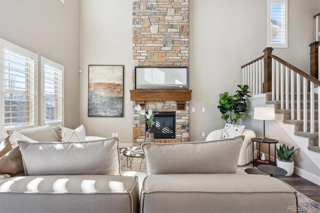 living room featuring hardwood / wood-style flooring, a stone fireplace, and a wealth of natural light