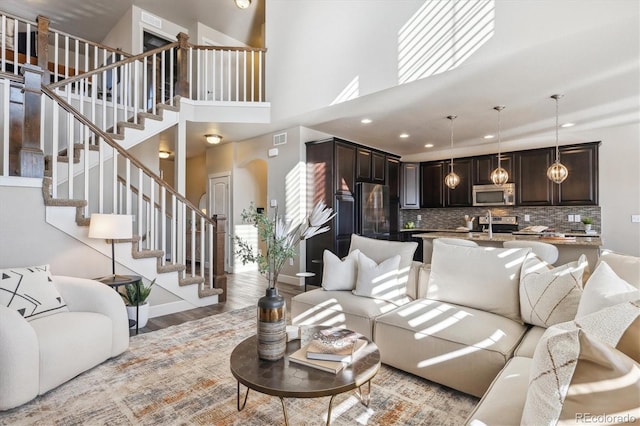 living room featuring a high ceiling and light hardwood / wood-style flooring