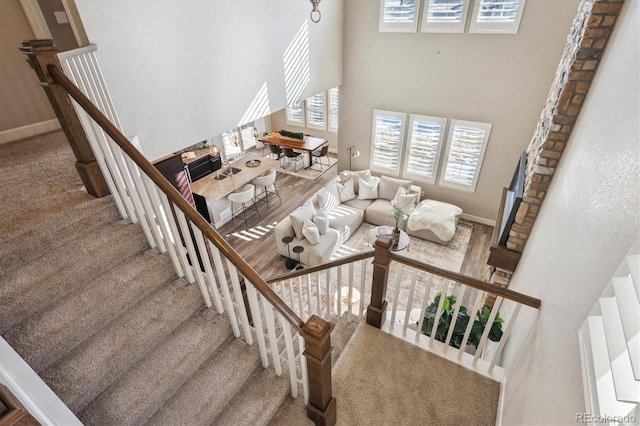 stairs featuring carpet floors and a towering ceiling