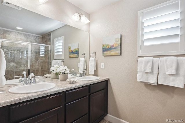 bathroom with vanity and a shower with door