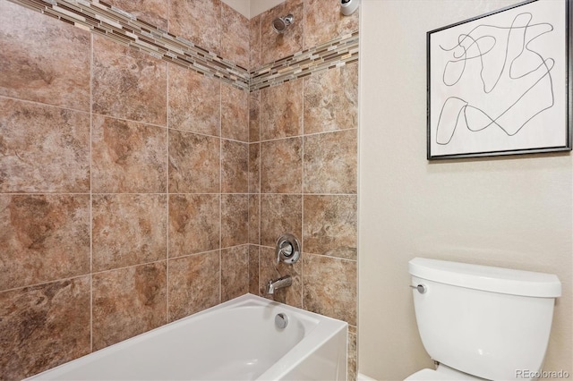 bathroom with tiled shower / bath combo and toilet