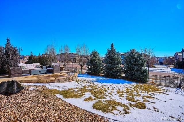 yard layered in snow featuring an outdoor living space