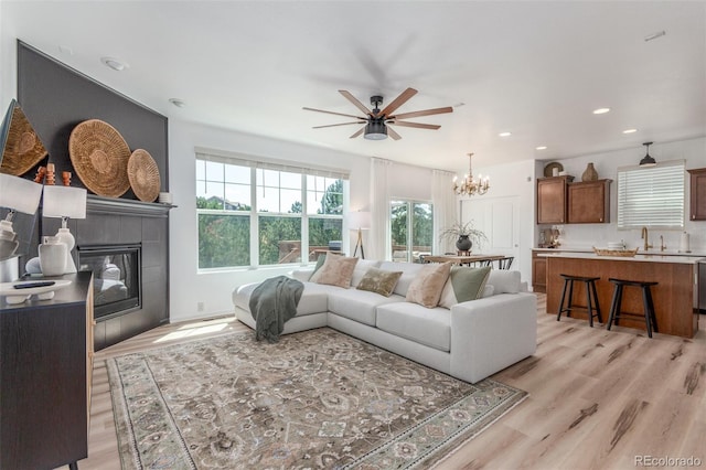 6400 S Ider St, Aurora, CO 80016 - living area with light wood finished floors, a fireplace, a chandelier, a ceiling fan, and recessed lighting