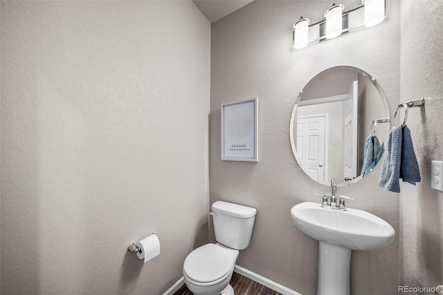 half bath with wood finished floors and toilet