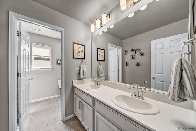 bathroom with double vanity, tile patterned floors, visible vents, and a sink