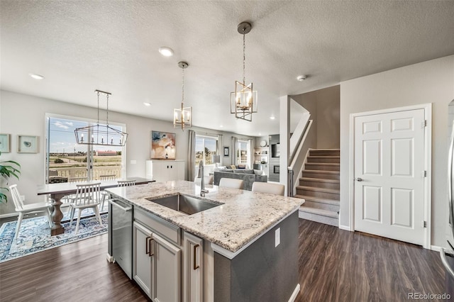 kitchen with a sink, dark wood-style flooring, a chandelier, and hanging light fixtures