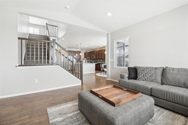 living room featuring lofted ceiling, sink, and dark hardwood / wood-style floors