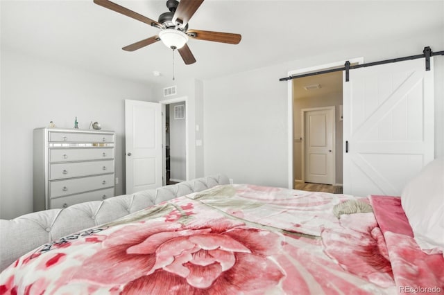 bedroom featuring a barn door and ceiling fan