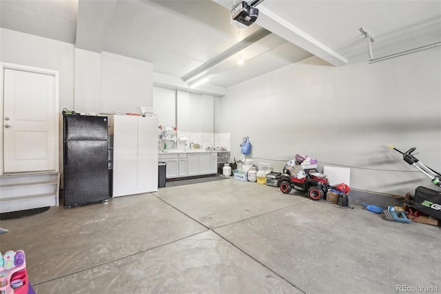 garage with a garage door opener and black fridge