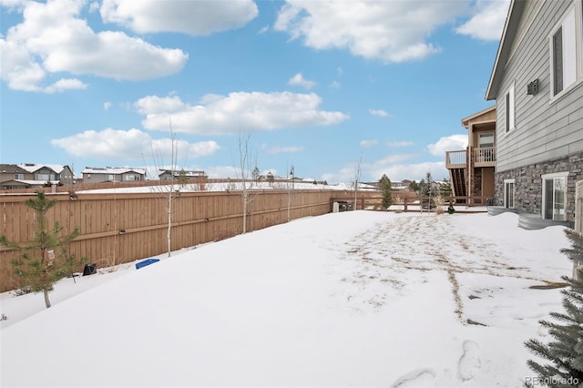 yard layered in snow with a balcony