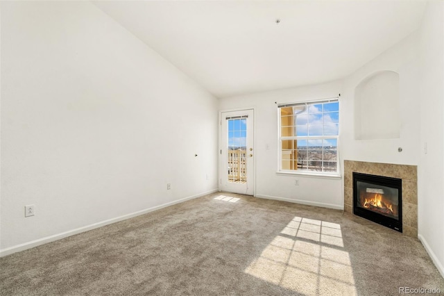 unfurnished living room featuring light colored carpet, a fireplace, and vaulted ceiling