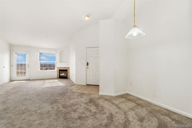 unfurnished living room with high vaulted ceiling, a fireplace, and light colored carpet