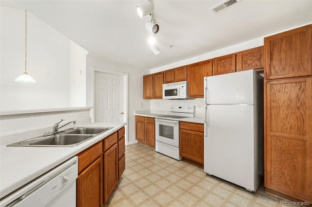 kitchen featuring pendant lighting, sink, white appliances, and track lighting