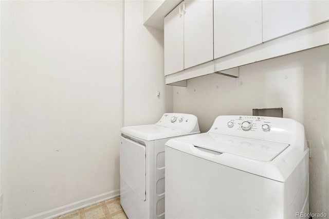 laundry room featuring cabinets and washer and clothes dryer