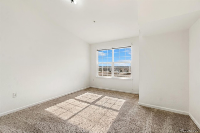 carpeted spare room featuring lofted ceiling