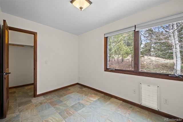 13012 S Wamblee Valley Rd, Conifer, CO 80433 - spare room featuring stone finish floors, radiator, and baseboards