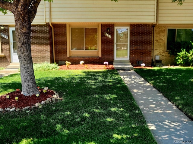 view of exterior entry with a lawn