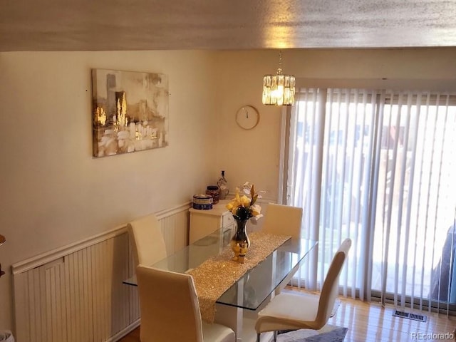 dining space featuring a textured ceiling, radiator heating unit, and a notable chandelier