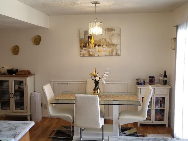 dining area with dark hardwood / wood-style floors and a textured ceiling