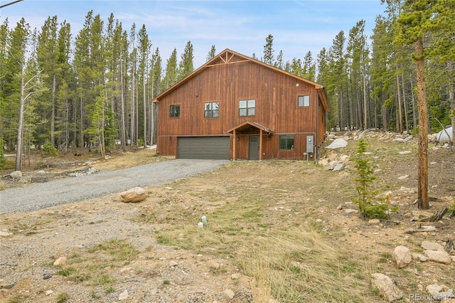 79 Beaver Rd, Idaho Springs, CO 80452 - view of side of home with gravel driveway, a wooded view, and an attached garage