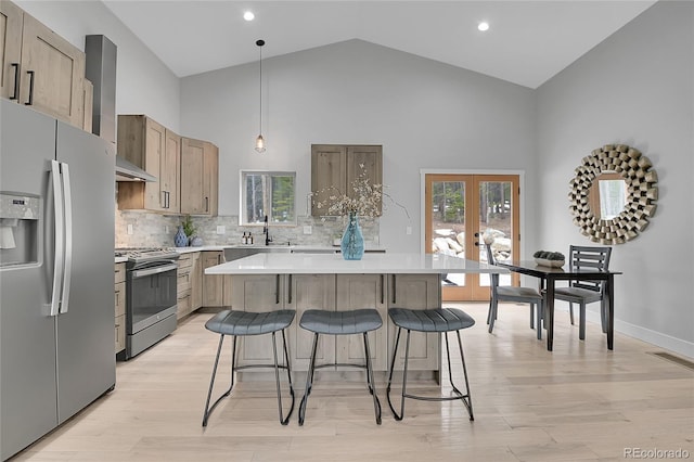 79 Beaver Rd, Idaho Springs, CO 80452 - kitchen featuring appliances with stainless steel finishes, high vaulted ceiling, a breakfast bar, light countertops, and a kitchen island