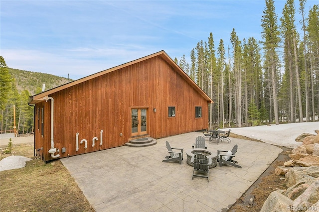 79 Beaver Rd, Idaho Springs, CO 80452 - back of house with an outdoor fire pit, french doors, a patio, and a wooded view