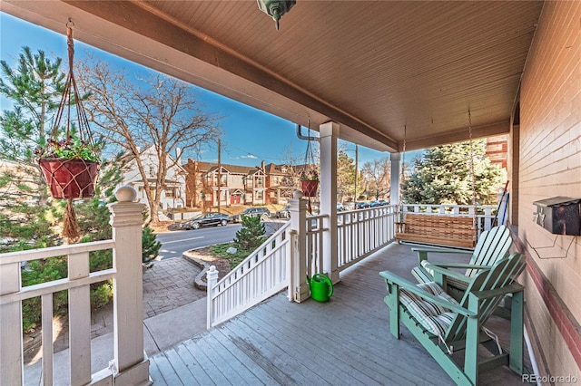 wooden terrace with a residential view and covered porch