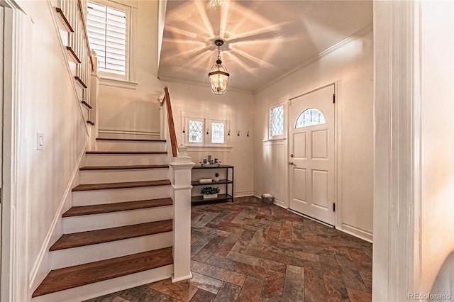 entrance foyer with stairway, crown molding, and baseboards