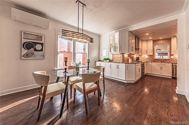 dining room featuring baseboards, dark wood-style flooring, a wall mounted air conditioner, a textured ceiling, and crown molding