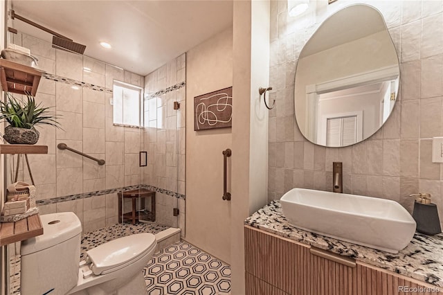 full bath featuring tile walls, toilet, a stall shower, and a sink