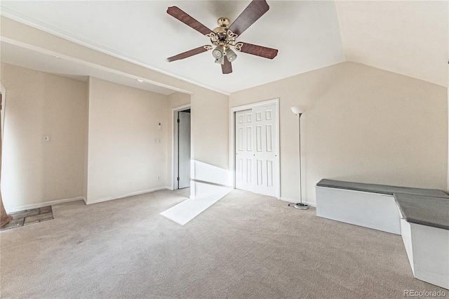 interior space with a closet, ceiling fan, carpet, and vaulted ceiling