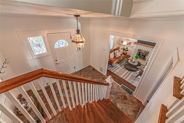 entryway featuring visible vents, a fireplace, and stone finish floor