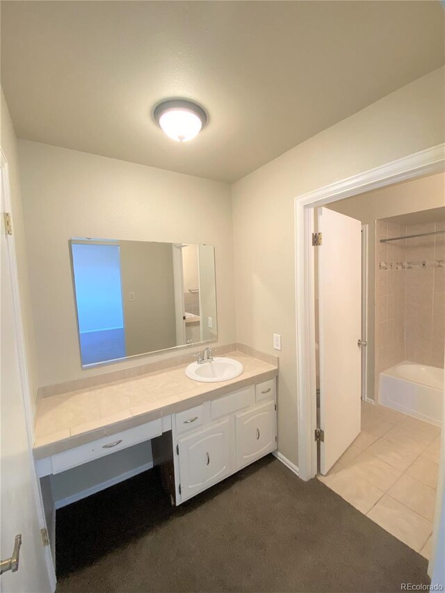 bathroom with tile patterned flooring, vanity, and tiled shower / bath