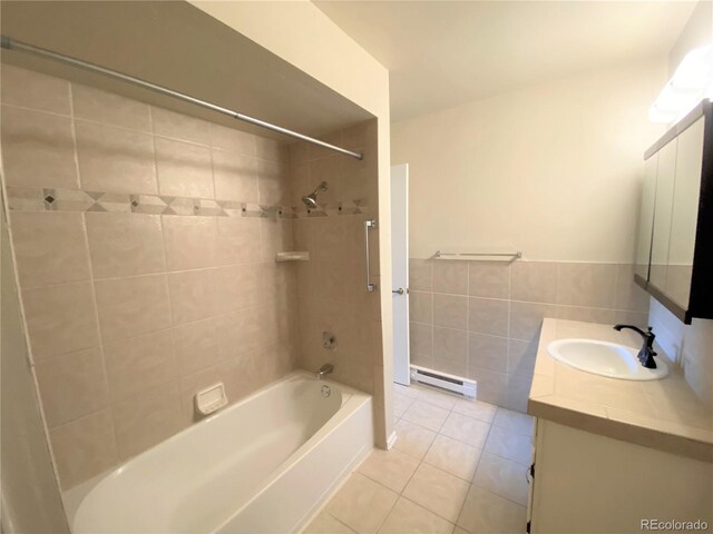 bathroom featuring a baseboard radiator, tile patterned flooring, vanity, tile walls, and tiled shower / bath