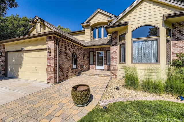 7043 S Owens Way, Littleton, CO 80127 - view of front of property featuring brick siding, a garage, and concrete driveway