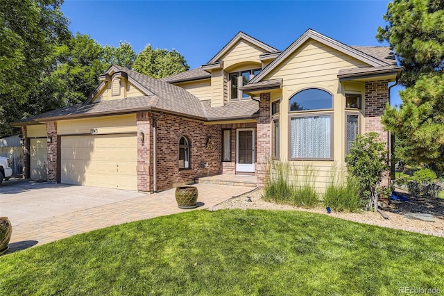 7043 S Owens Way, Littleton, CO 80127 - view of front of house with brick siding, an attached garage, a front lawn, driveway, and a shingled roof