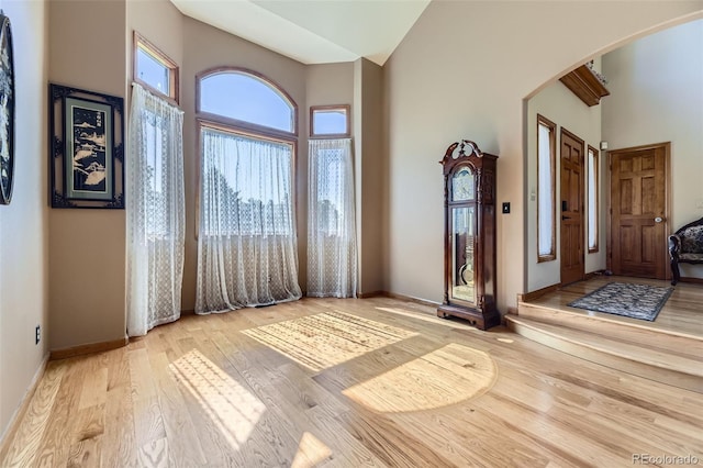 7043 S Owens Way, Littleton, CO 80127 - entrance foyer featuring arched walkways, a towering ceiling, and wood finished floors