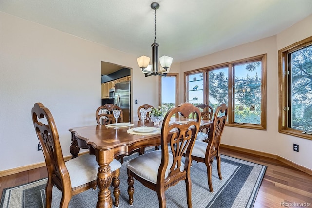 7043 S Owens Way, Littleton, CO 80127 - dining area with a chandelier, healthy amount of natural light, and light wood-style floors