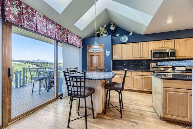 7043 S Owens Way, Littleton, CO 80127 - kitchen featuring stainless steel appliances, a skylight, light brown cabinets, light wood-style flooring, and lofted ceiling