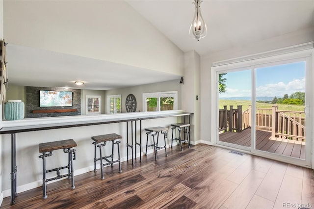 7311 Rattlesnake Dr, Lone Tree, CO 80124 - kitchen with wood finished floors, vaulted ceiling, a kitchen breakfast bar, and hanging light fixtures