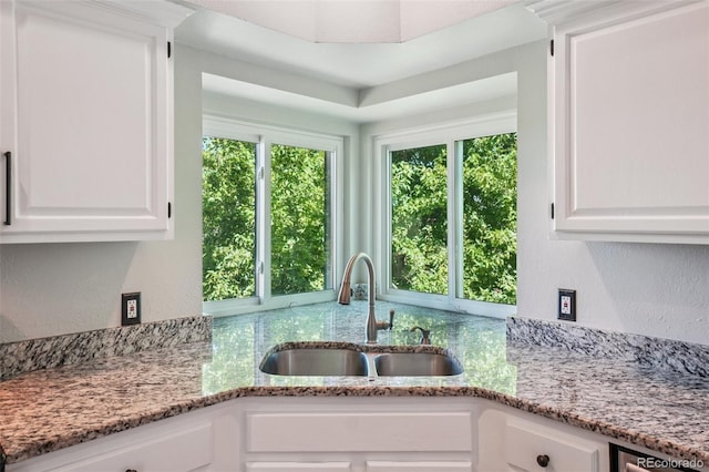 7311 Rattlesnake Dr, Lone Tree, CO 80124 - kitchen featuring white cabinets, light stone countertops, and a textured wall