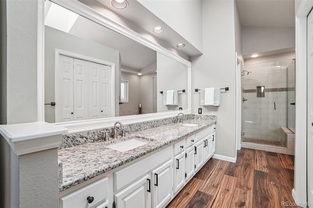 7311 Rattlesnake Dr, Lone Tree, CO 80124 - bathroom featuring double vanity, a shower stall, recessed lighting, wood finished floors, and lofted ceiling