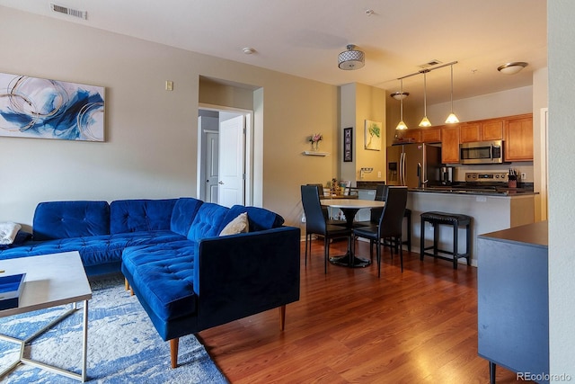 living room with dark hardwood / wood-style floors and rail lighting