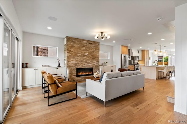 1645 N Osceola St, Denver, CO 80204 - living room with light wood-style flooring, healthy amount of natural light, a fireplace, recessed lighting, and a chandelier
