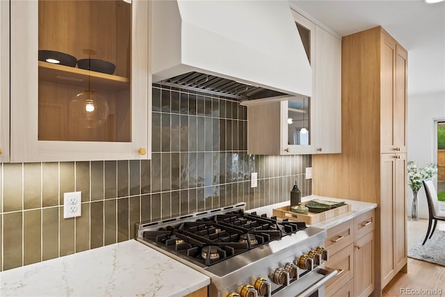 1645 N Osceola St, Denver, CO 80204 - kitchen with custom exhaust hood, high end stove, light stone countertops, tasteful backsplash, and glass insert cabinets
