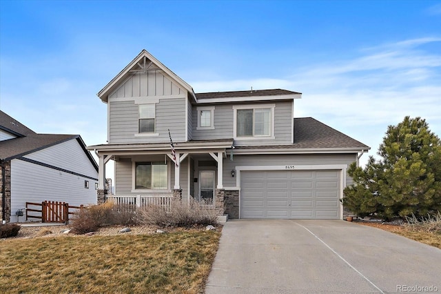 view of front of house featuring a garage, concrete driveway, stone siding, a porch, and board and batten siding