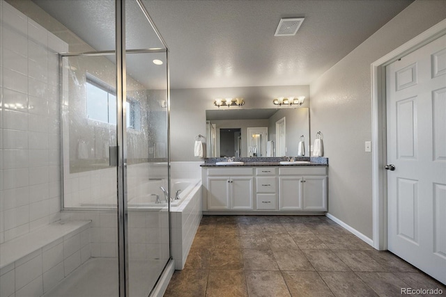 bathroom with vanity, a textured ceiling, and separate shower and tub