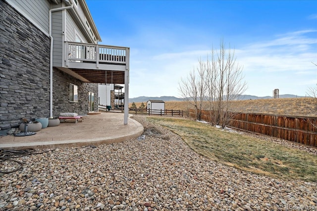 view of yard with a deck with mountain view and a patio